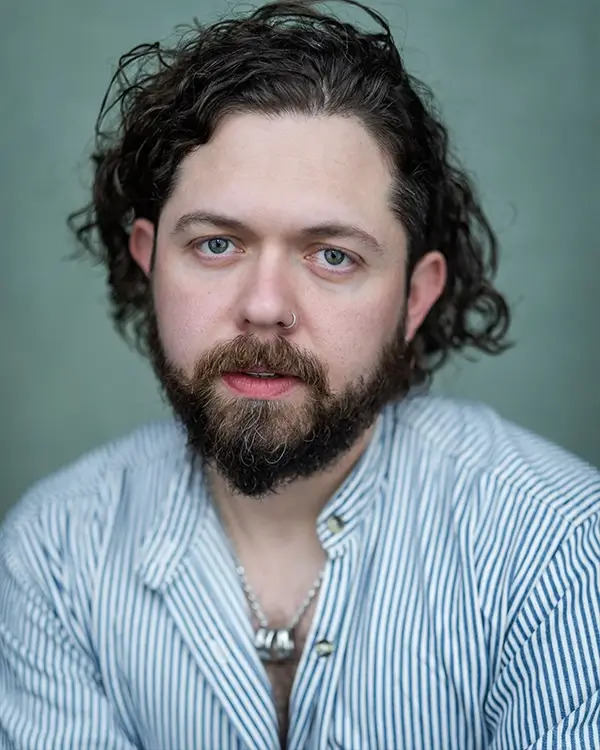 Keith Higinbotham wearing a stripy blue and white shirt, looking at the camera. Head and shoulder shot.